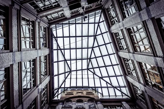 A photograph of a glass ceiling inside a building, taken from directly beneath.
